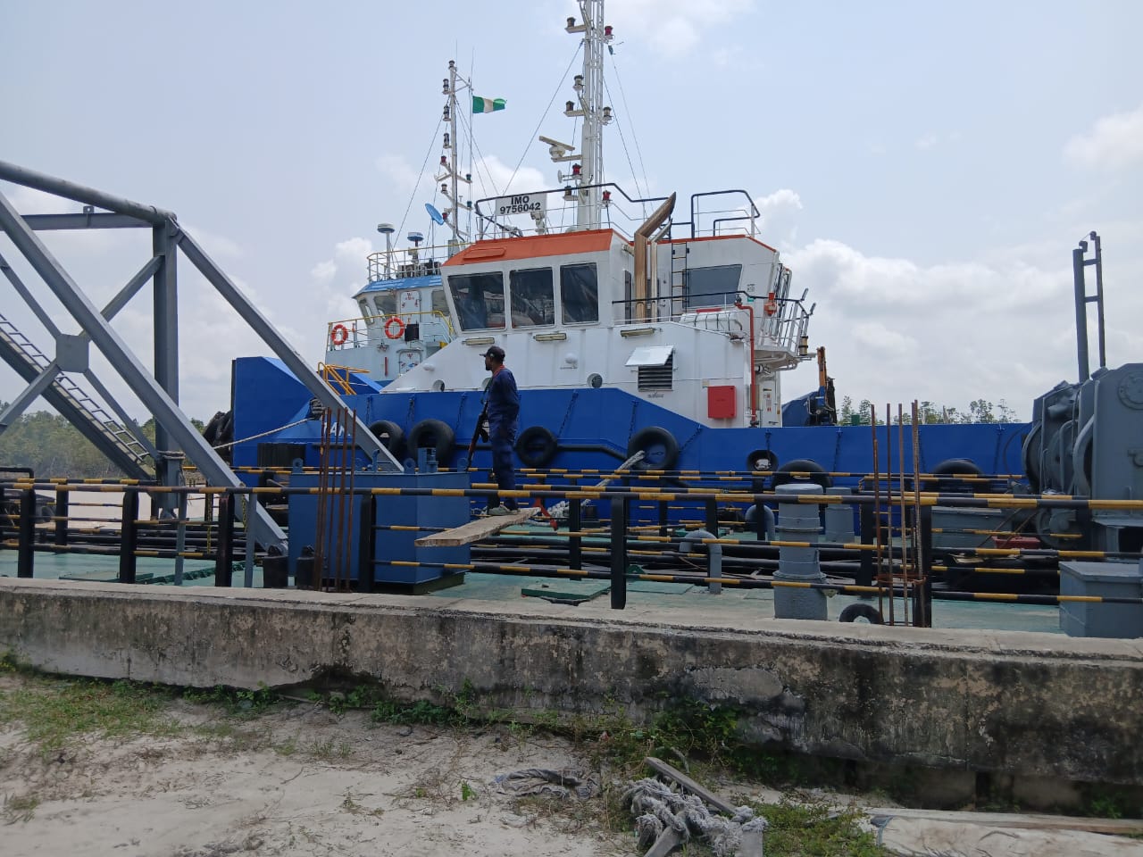 Offshore tug boat at the quay with crew member on deck